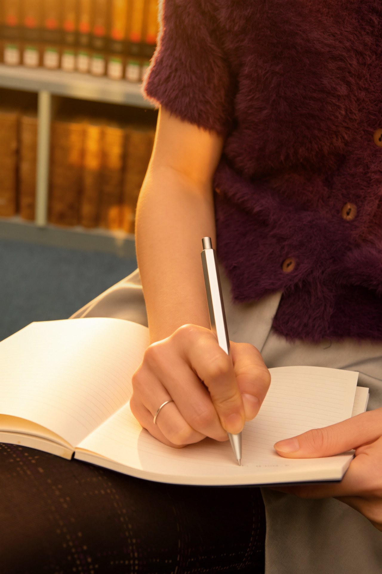 A hand writing in an open notebook